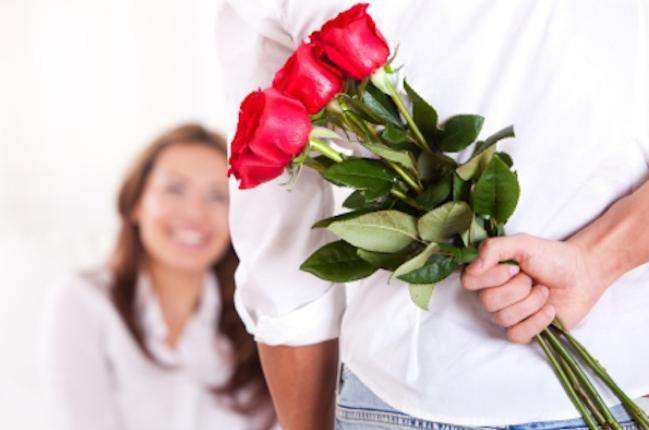 Mężczyzna trzyma ukryte za plecami róże